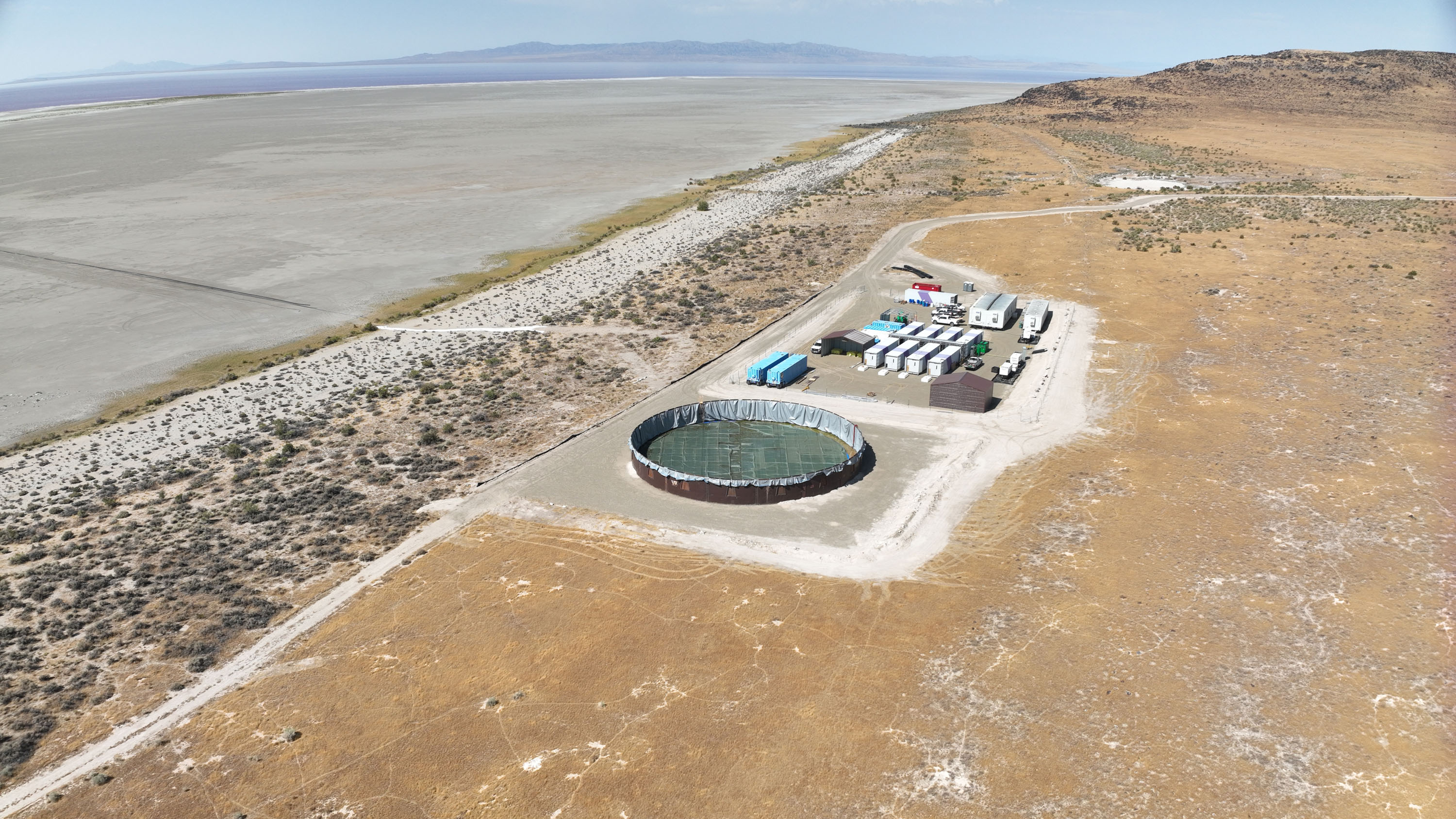 aerial image of the Lilac facility with a large circular tank draped in plastic sheet in the foreground and grids of trailers amongst the buildings adjacent to it.