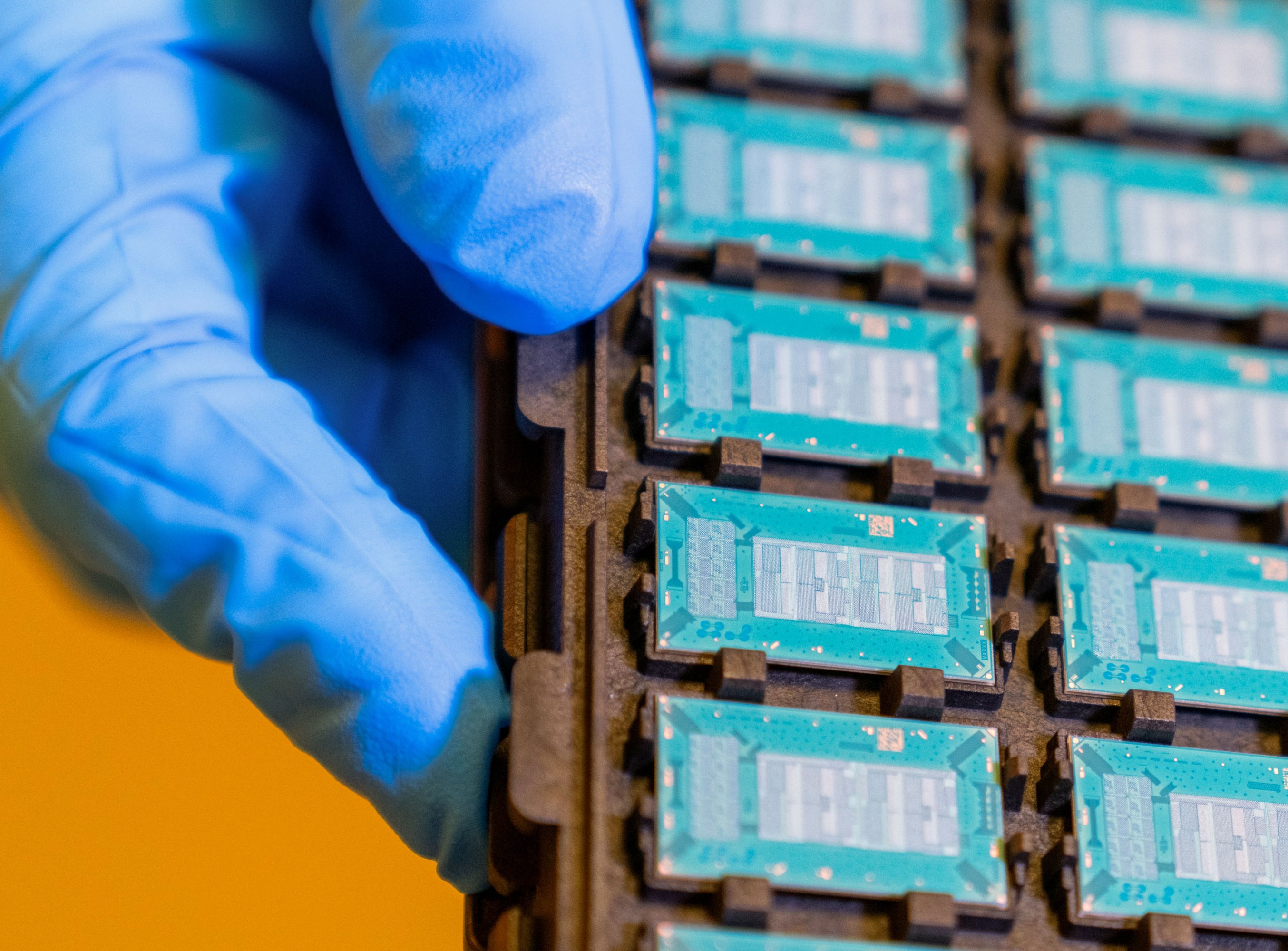 close up on a grid of glass substrate test units held by a gloved hand